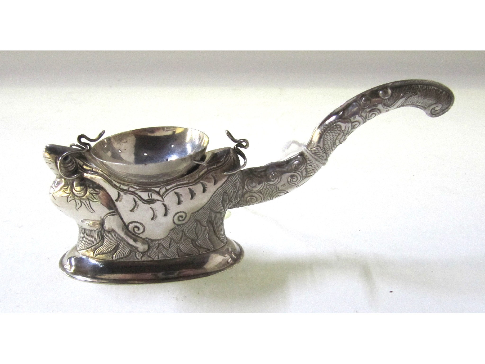 Appraisal: A Vietnamese silver strainer modelled as a stylised fish