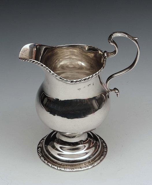 Appraisal: A GEORGE III SILVER HELMET SHAPED CREAM JUG with a