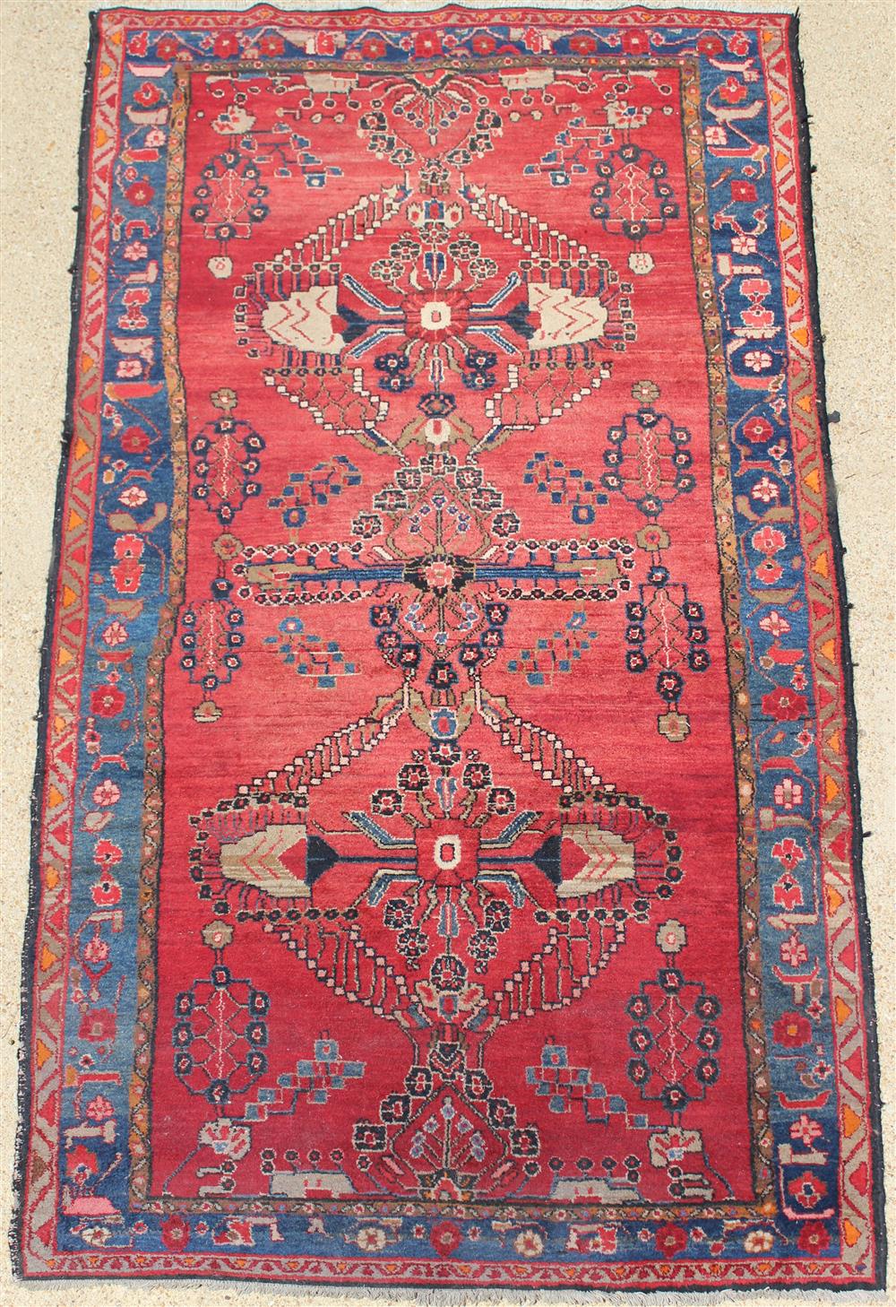 Appraisal: PERSIAN GEOMETRIC FLORAL WOOL RUG motifs on a red field