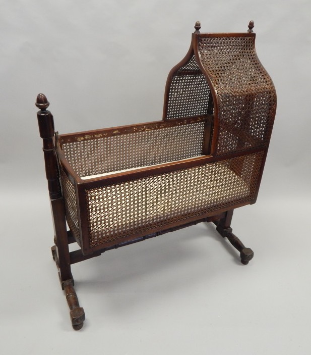 Appraisal: A thC mahogany and caned crib with an arched top