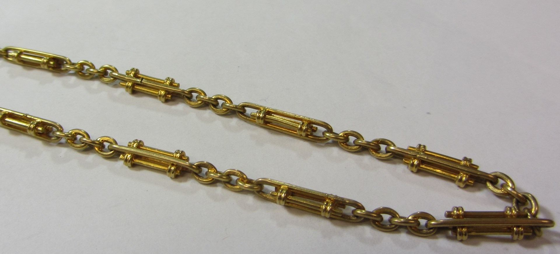 Appraisal: An ct gold decorated twin bar and oval link neckchain