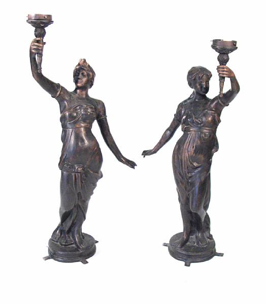 Appraisal: A pair of patinated bronze figural torcheres one lacking glass