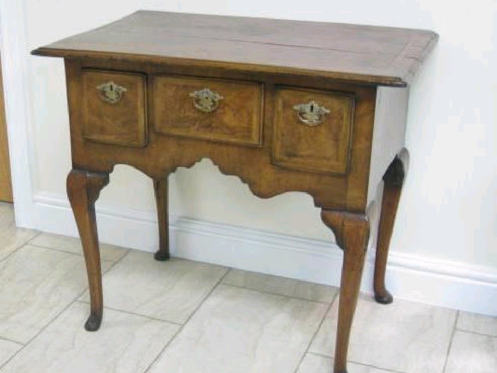 Appraisal: An antique walnut Lowboy with quarter veneered top fitted three