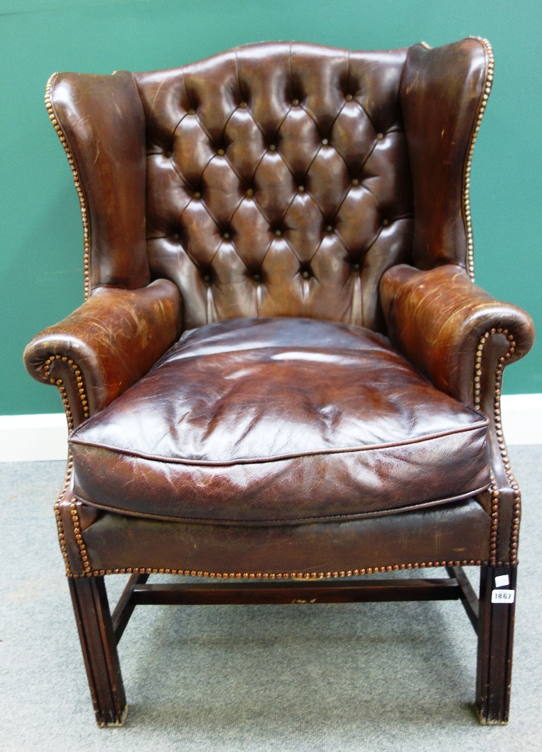 Appraisal: An th century style brown leather upholstered wingback armchair on