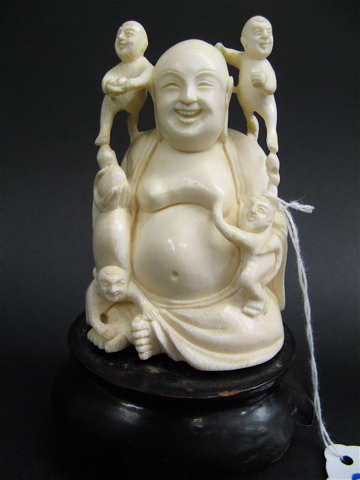 Appraisal: SOLID IVORY CARVED FIGURE OF A BENEVOLENT BUDDHA with children