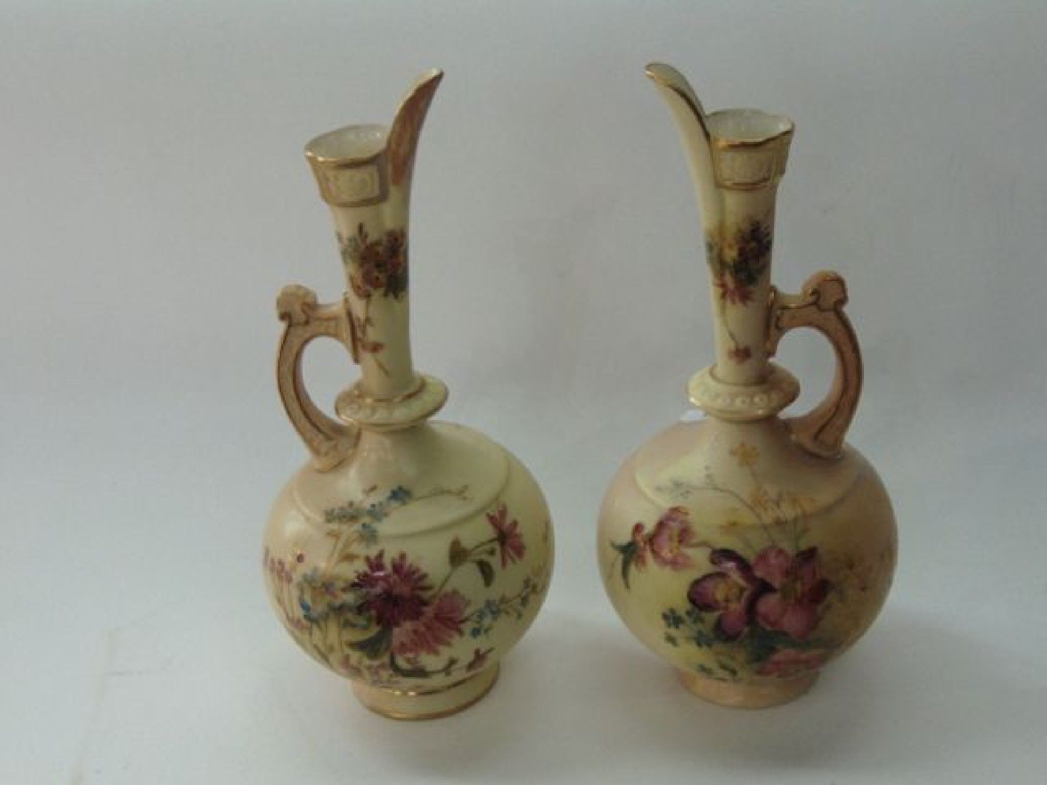 Appraisal: A matched pair of Royal Worcester blush ivory ewers with