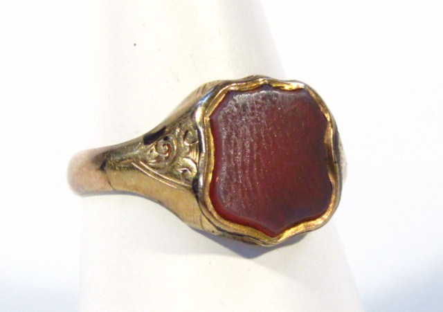 Appraisal: A gentleman's signet ring set with polished stone centre yellow