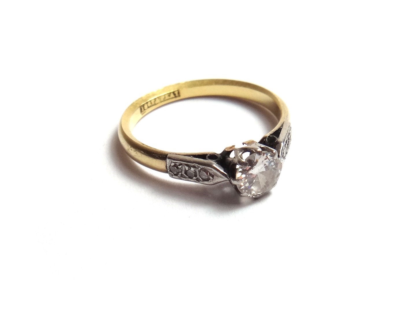 Appraisal: A gold and platinum diamond set single stone ring claw