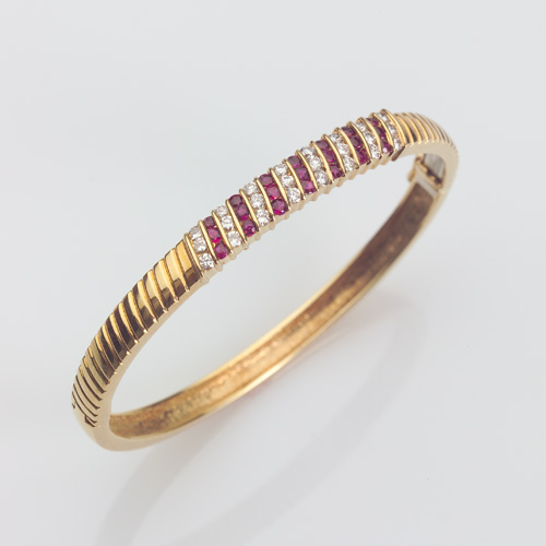 Appraisal: DIAMOND AND RUBY Hinged bangle in k yellow gold The