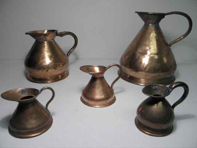 Appraisal: Five English hammered copper measuring jugs Includes a gallon jug