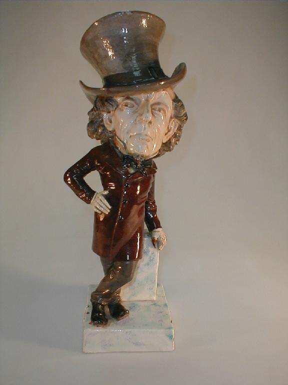 Appraisal: A glazed pottery caricature figure of Benjamin Disraeli wearing a