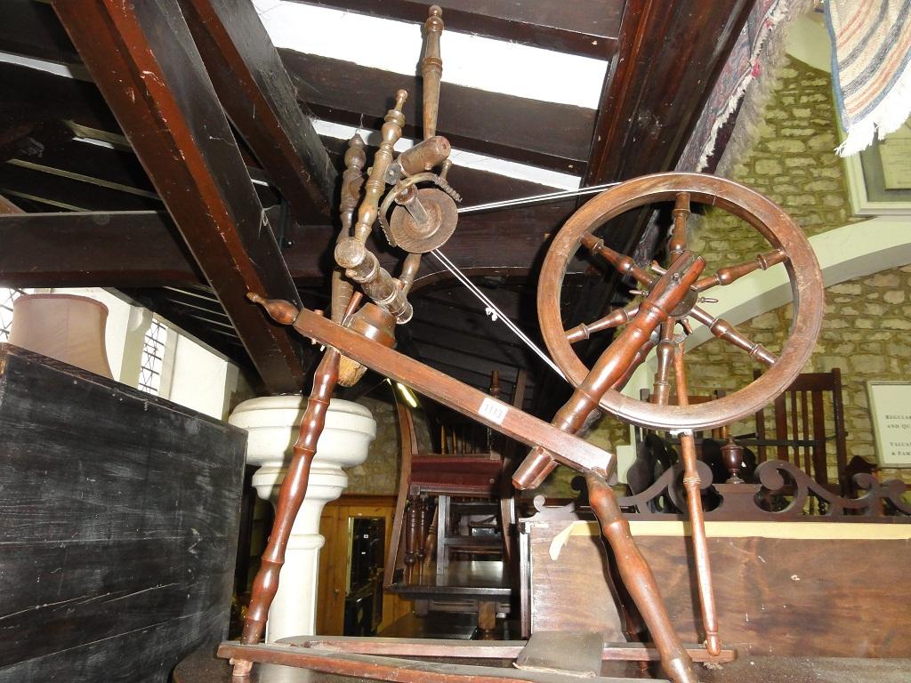 Appraisal: A vintage floor standing treadle spinning wheel and attachments raised