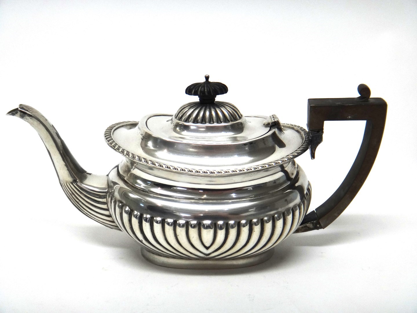 Appraisal: A silver teapot of boat shaped form with partly fluted