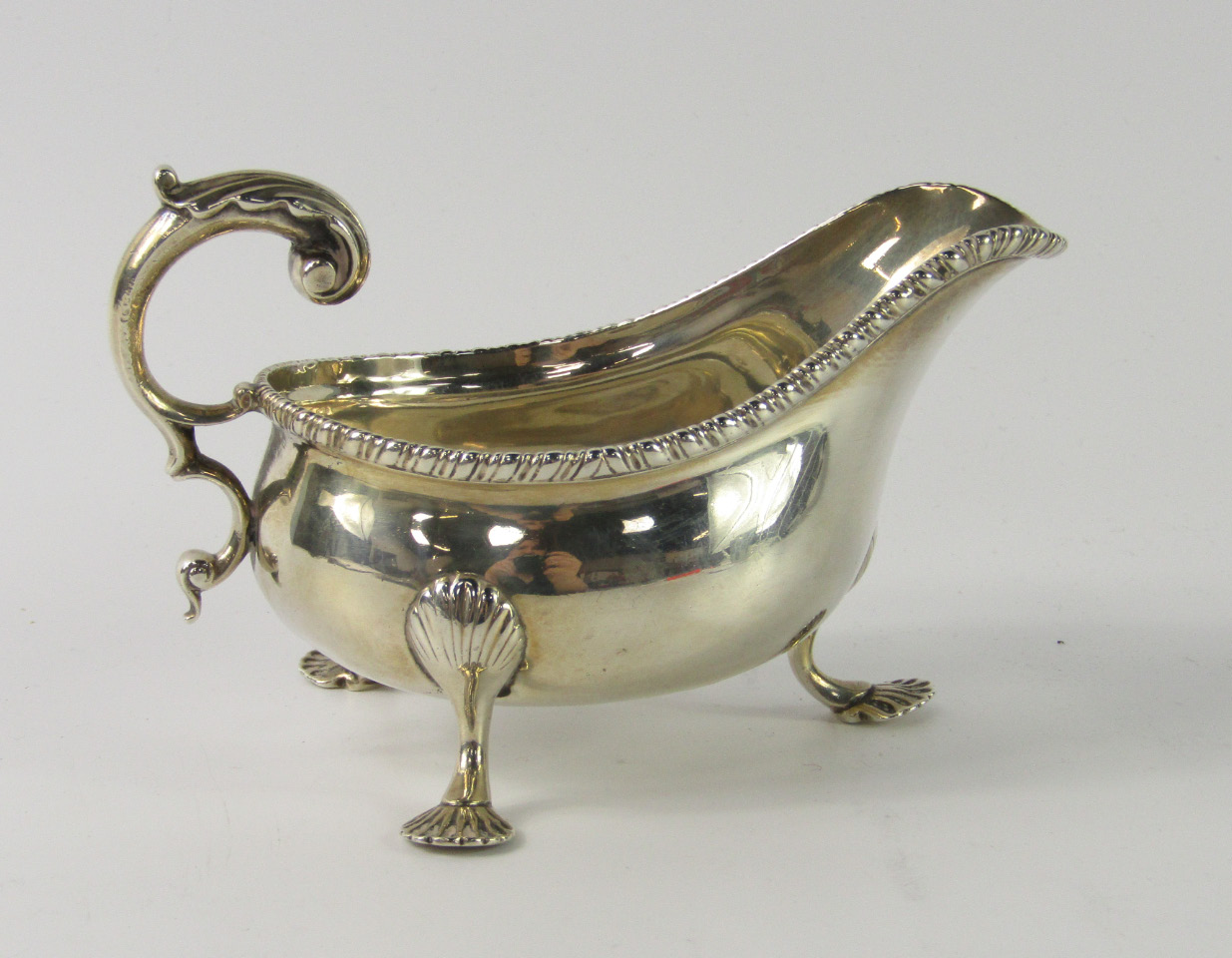 Appraisal: A Victorian silver sauce boat with a gadrooned rim raised