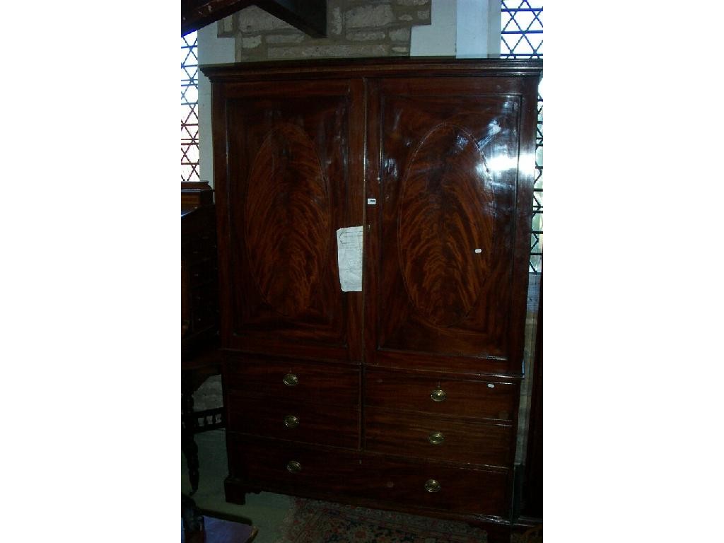 Appraisal: A Georgian mahogany wardrobe enclosed by panelled doors incorporating false