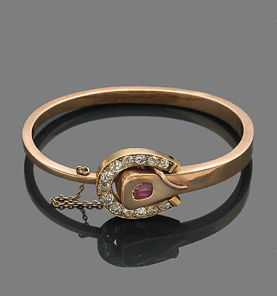 Appraisal: A diamond ruby and fourteen karat bicolor gold buckle bangle