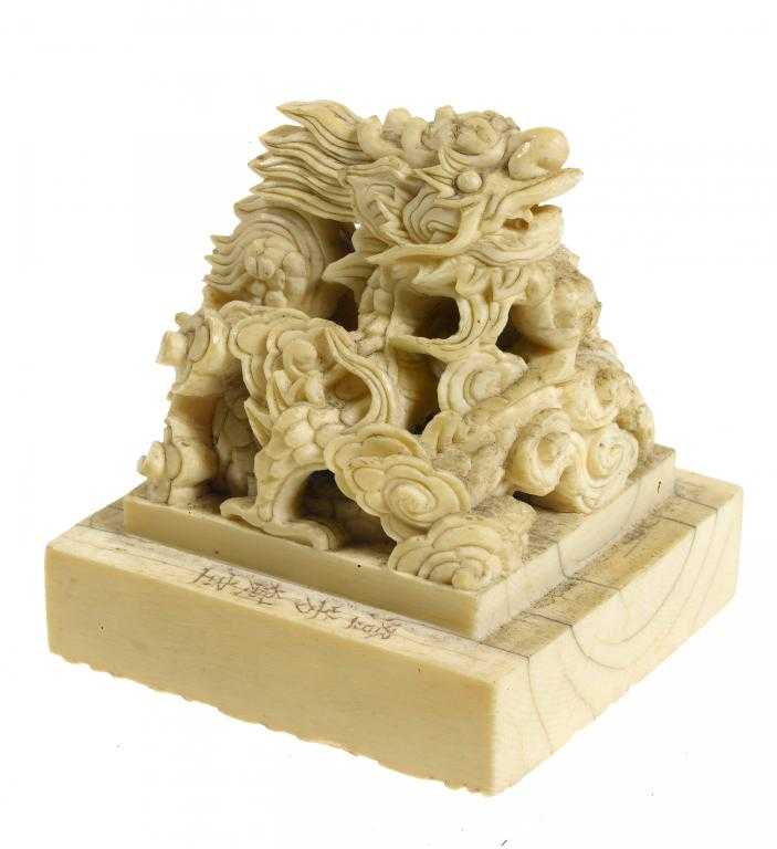 Appraisal: AN IVORY SEAL carved from a square block with a