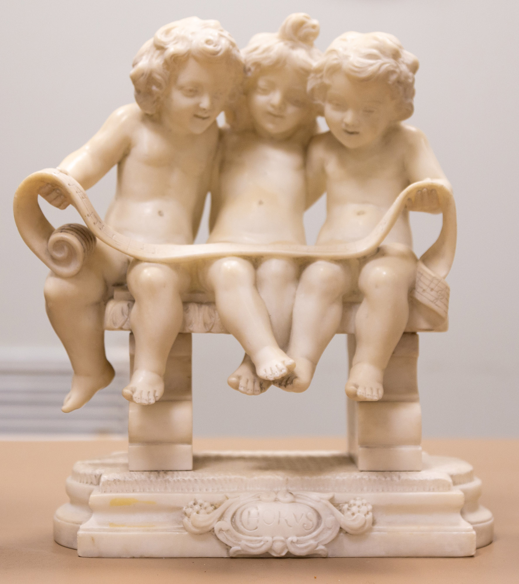 Appraisal: ALABASTER SCULPTURE OF PUTTI HOLDING SHEET MUSIC Early th century