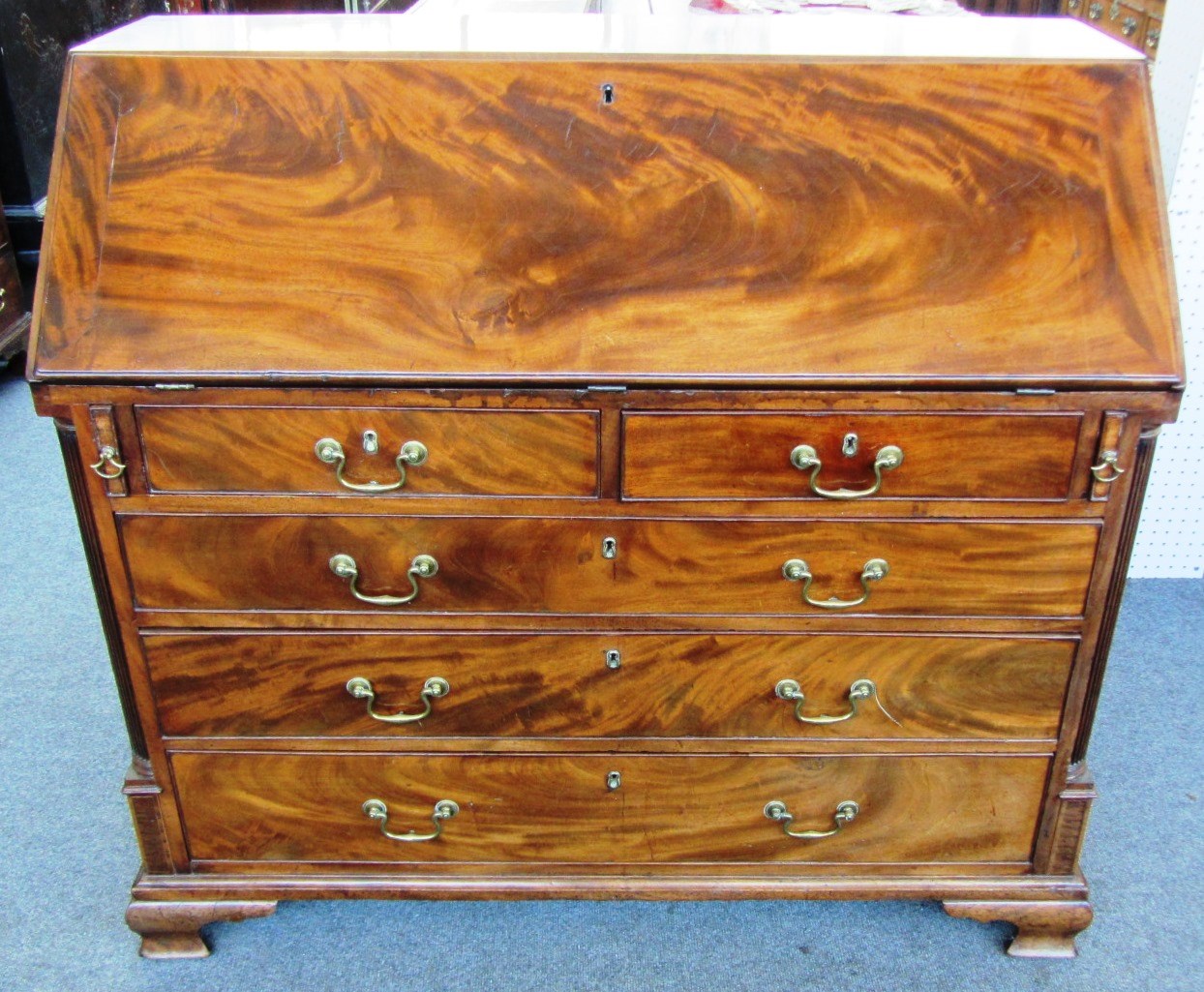 Appraisal: A George III mahogany bureau the fall enclosing a fitted