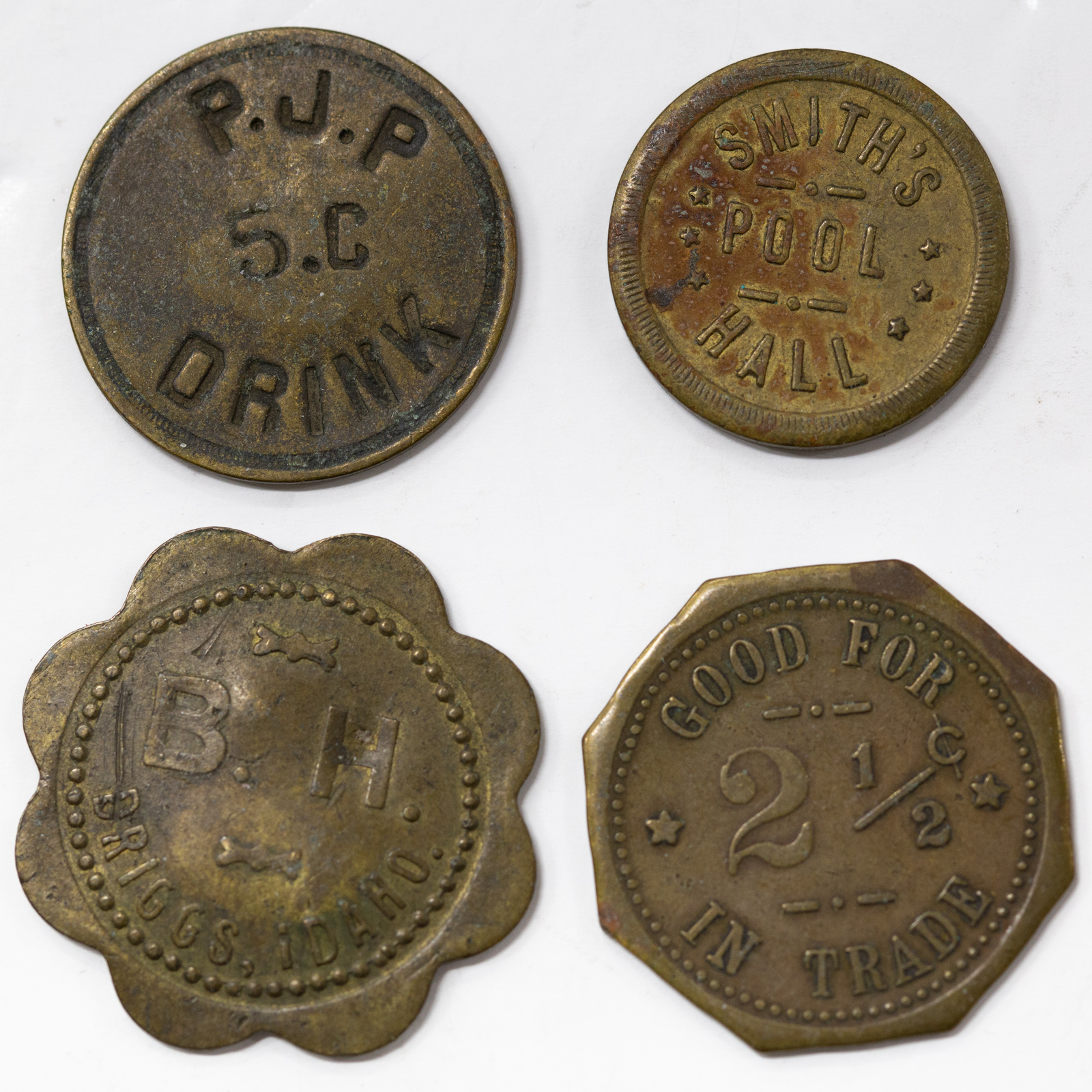 Appraisal: FOUR INTERESTING STORE MERCHANT TOKENS Octagonal shaped Sunny Side Liquor