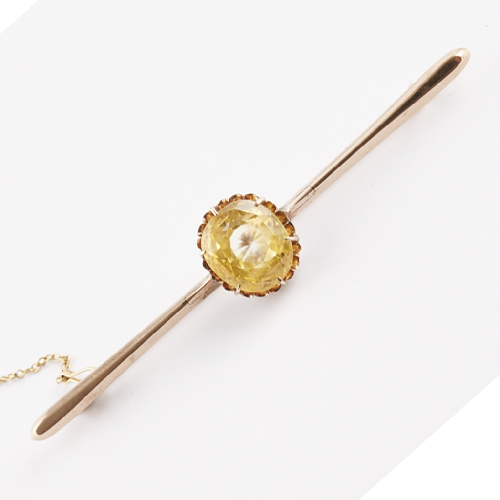 Appraisal: A yellow sapphire set bar brooch claw set with a