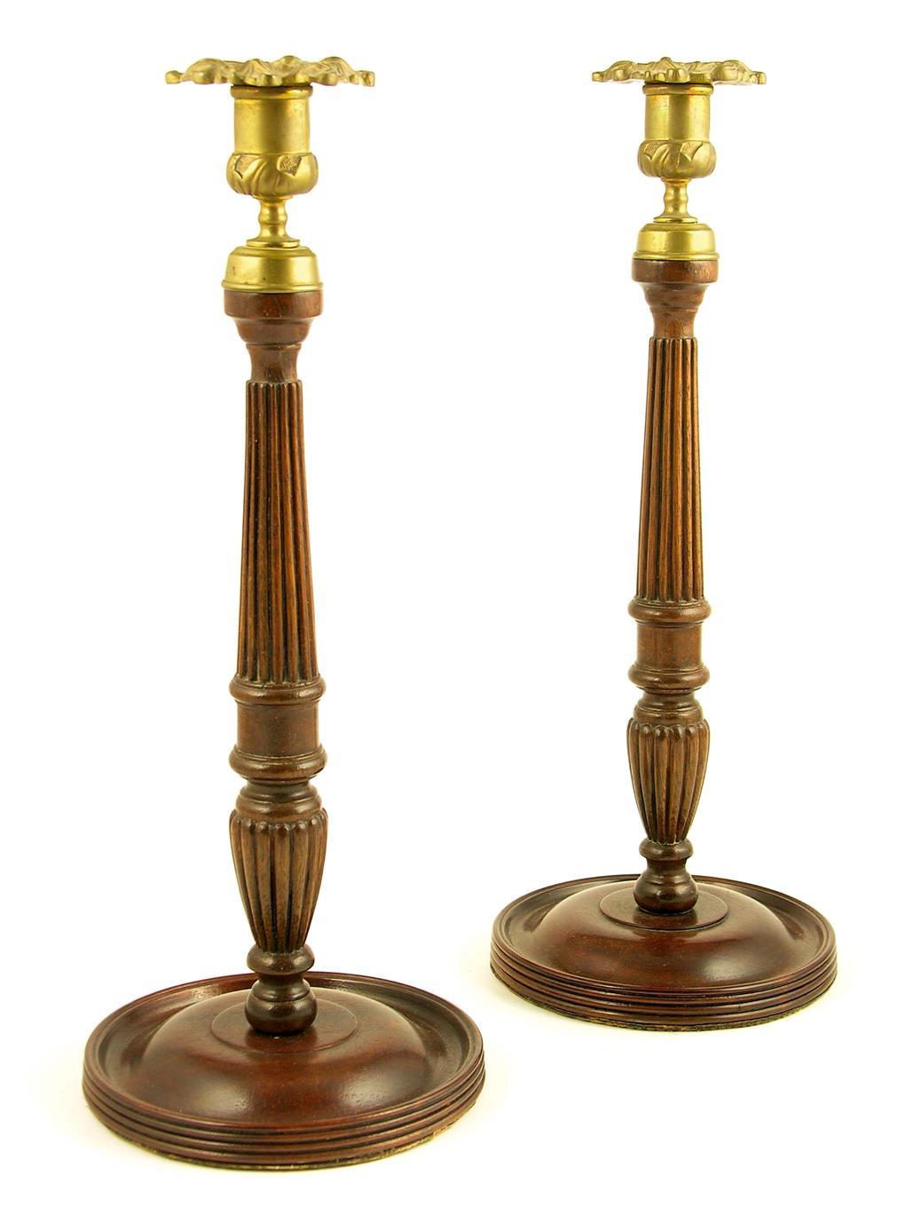 Appraisal: A pair of mahogany and brass mounted candlesticks in George