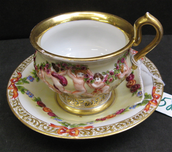 Appraisal: A CAPODIMONTE PORCELAIN TEA CUP AND SAUCER SET having raised