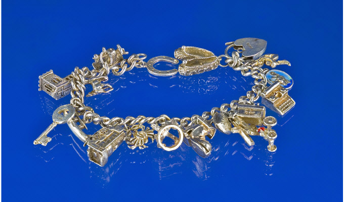 Appraisal: Charm Bracelet Loaded With Silver Charms Comprising Slippers Caravan Typewriter