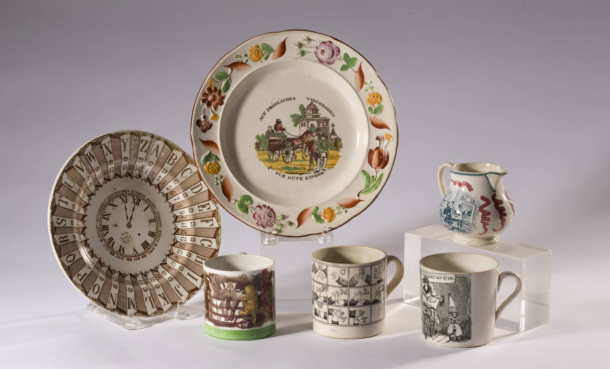 Appraisal: SIX ENGLISH TRANSFER-PRINTED CHILDREN quot S TABLEWARES INCLUDING A SIGN