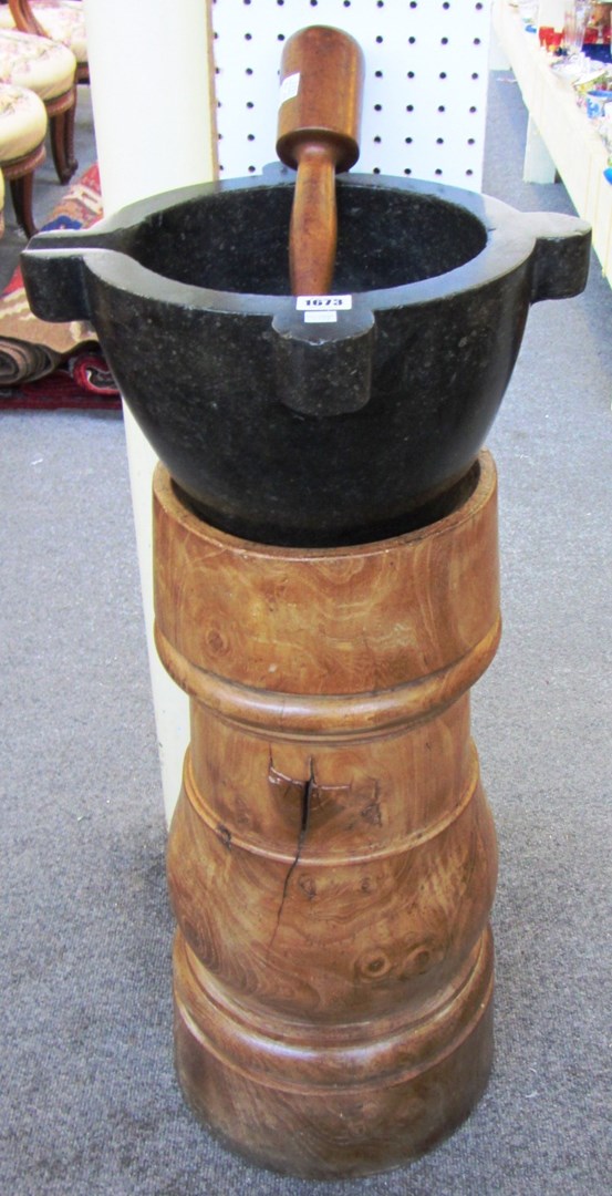 Appraisal: A black marble mortar on an elm stand th century