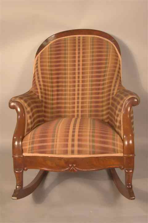 Appraisal: VICTORIAN STYLE MAHOGANY UPHOLSTERED ROCKING ARMCHAIR the arched cresting over