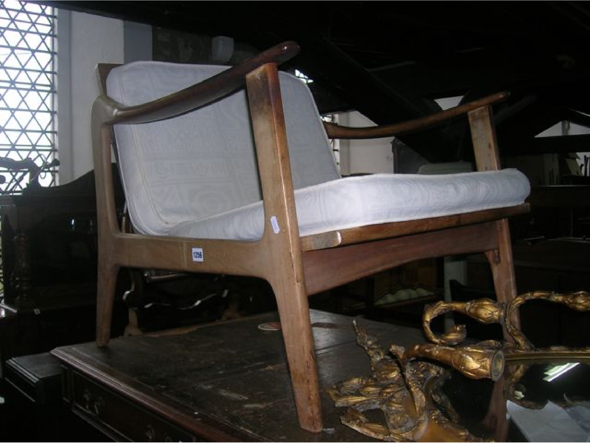 Appraisal: A mid th century teak framed open armchair with tapered