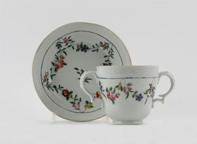 Appraisal: A Bristol two-handled cup and saucer with osier moulded rims