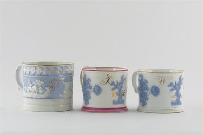 Appraisal: Two New Hall mugs with applied lavender blue flowers gilt