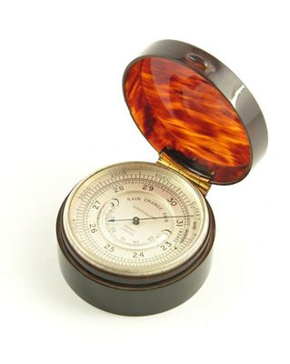 Appraisal: An aneroid desk barometer silvered dial inset with curved thermometer