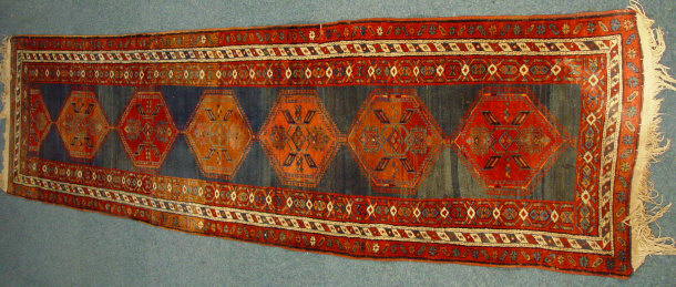 Appraisal: Rectangular blue and red carpet runner decorated with a geometric