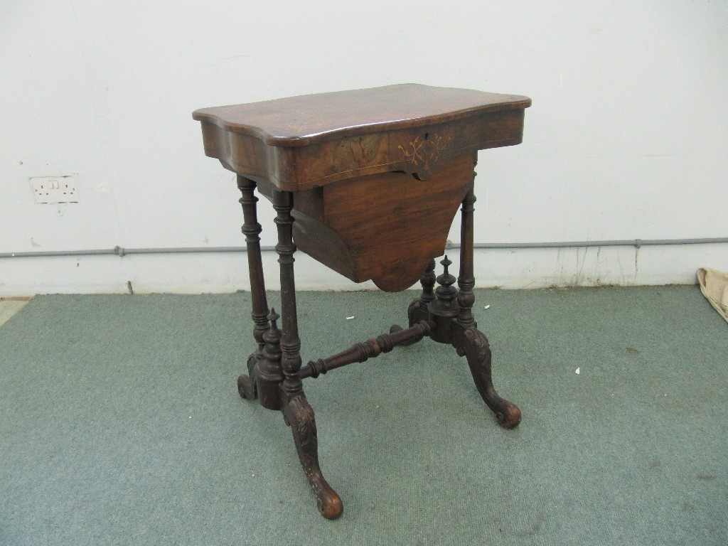 Appraisal: A Victorian walnut inlaid sewing table raised on spindle supports