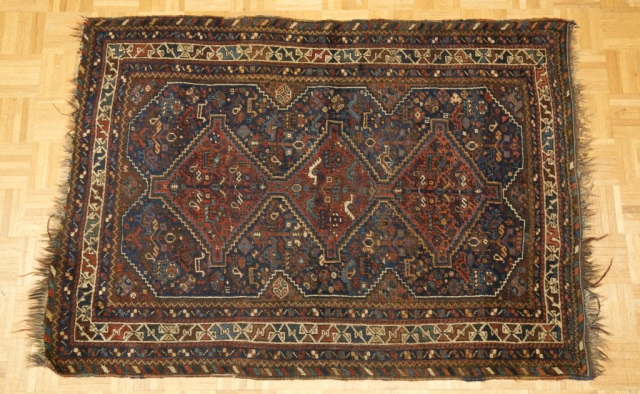 Appraisal: Caucasian Rug Dominant blue field with three rust-colored diamond medallions