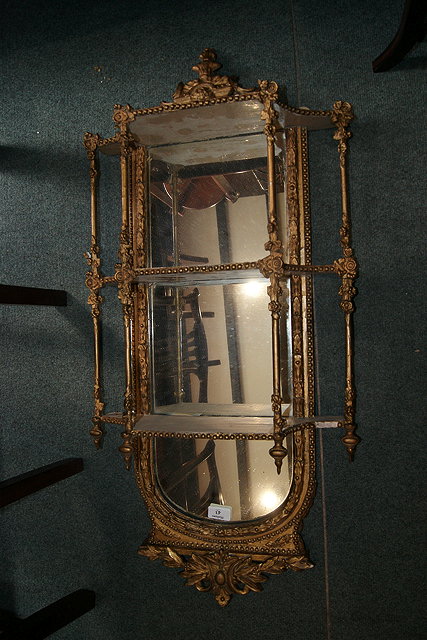 Appraisal: A VICTORIAN GILT PLASTER MIRROR with open shelves with leaf