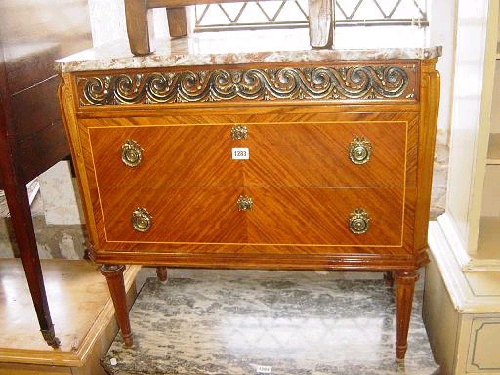 Appraisal: A continental commode fitted with three long drawers with well