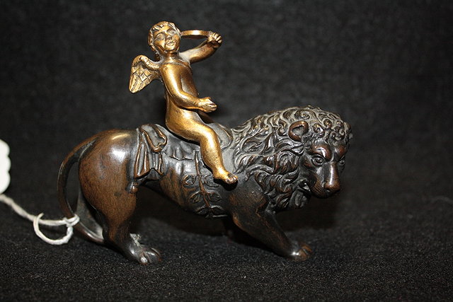 Appraisal: A BRONZE FIGURE GROUP showing a putti riding a lion