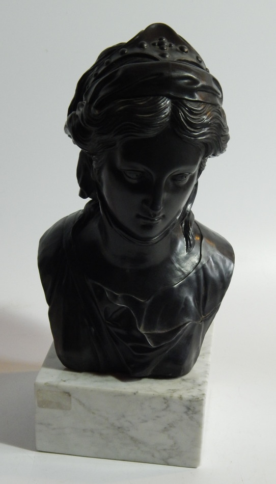 Appraisal: A black pottery bust of a young Grecian woman on