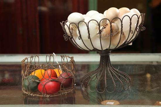 Appraisal: TWO WIRE BASKETS WITH EGGS One has a pedestal base