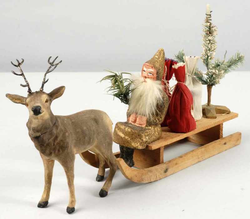 Appraisal: Composition Gold Santa on Wooden Sleigh Description With gifts and