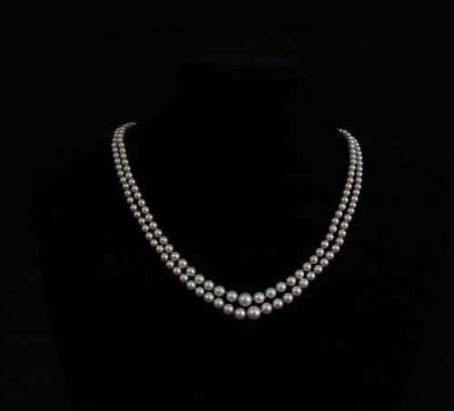 Appraisal: A two-row pearl necklace with an emerald and diamond cluster