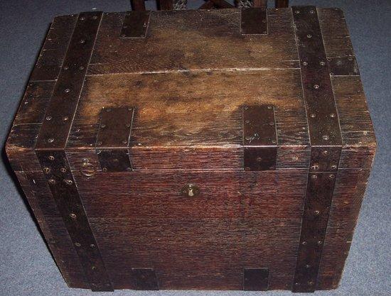 Appraisal: An oak and iron bound strong box the hinged lid