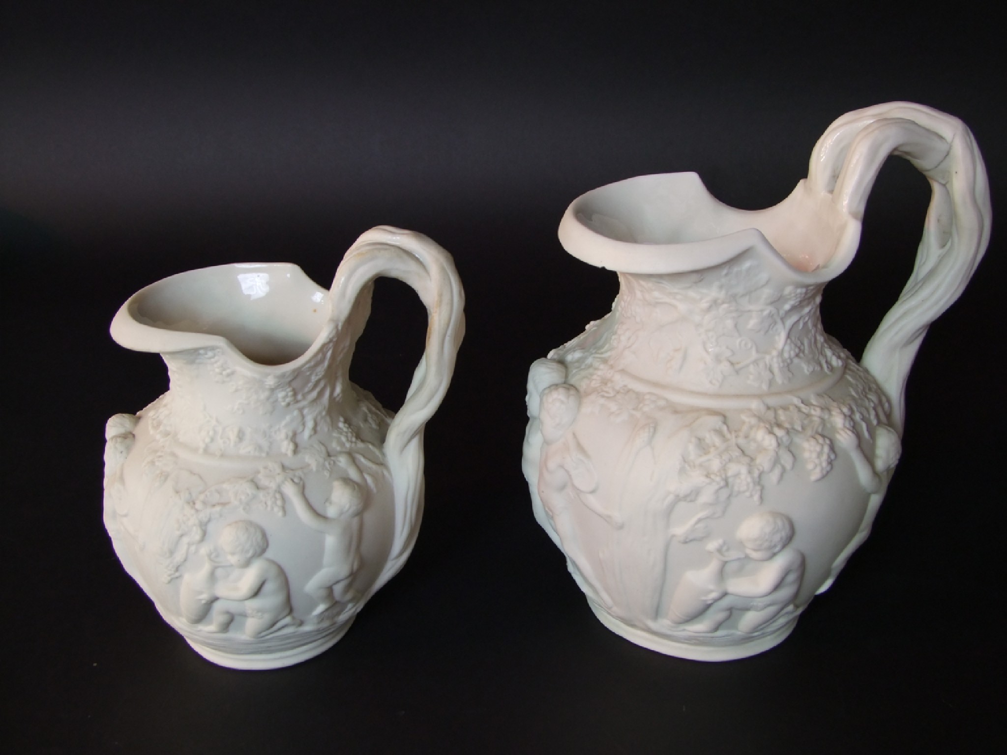 Appraisal: Two graduated th century Copeland white ground parian ware jugs