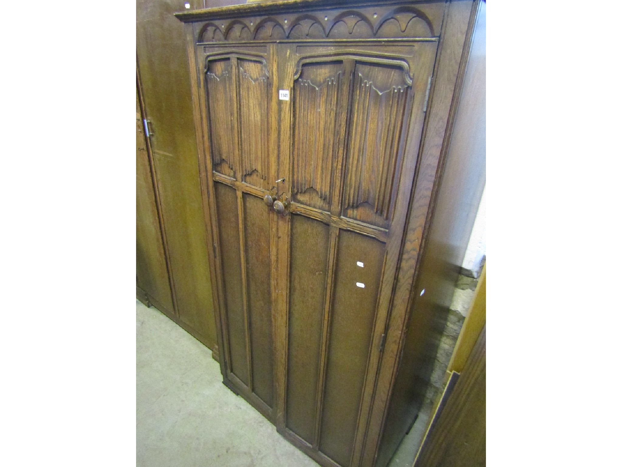 Appraisal: A small reproduction oak wardrobe enclosed by a pair of