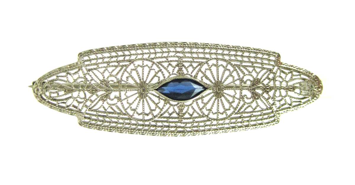 Appraisal: SAPPHIRE AND TEN KARAT WHITE GOLD FILIGREE PIN set with