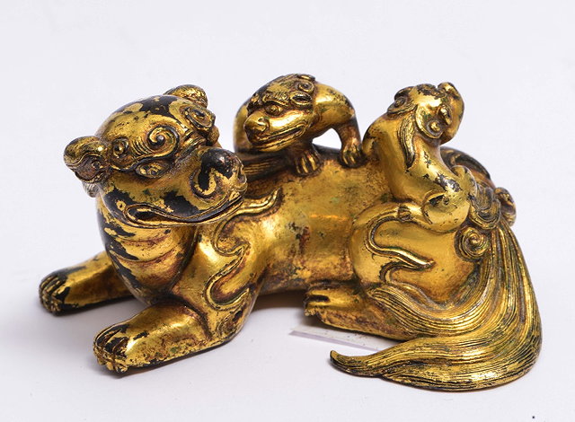 Appraisal: A CHINESE GILT BRONZE SCROLL WEIGHT in the form of